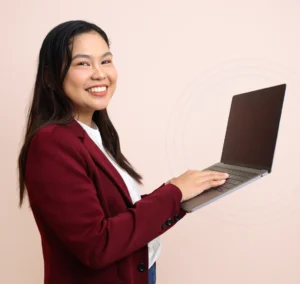 Roma smiling while holding a laptop