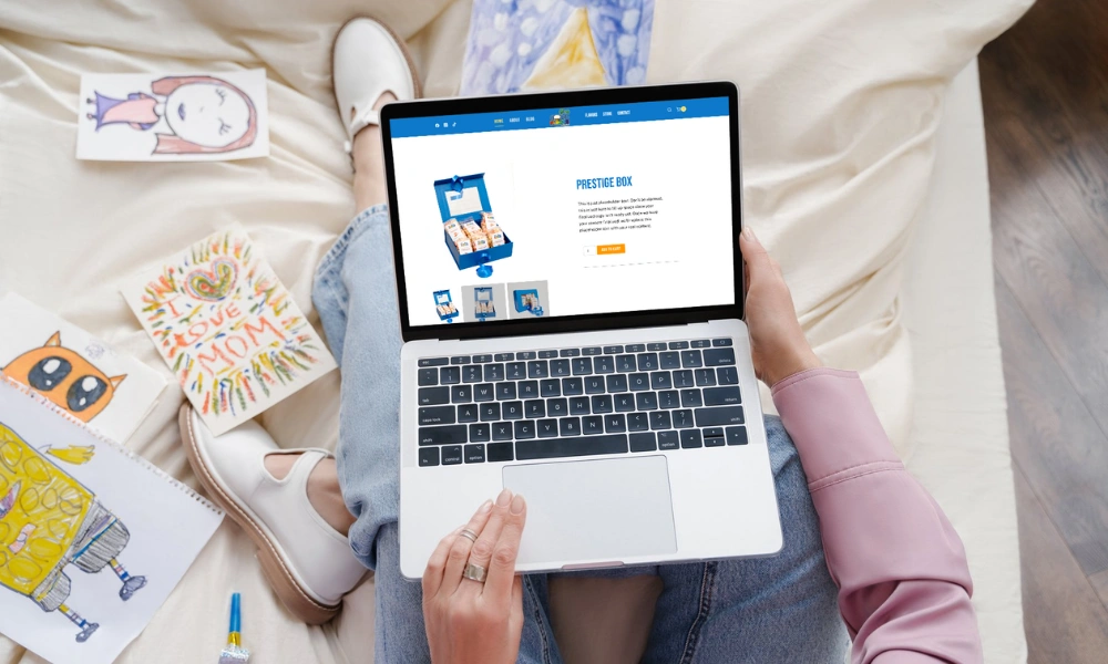 Overhead view of a laptop held on a lap displaying the Pop'N Flavors ecommerce product page and online shop layout.