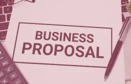 Document printed with the title Business Proposal alongside a pen, calculator, and keyboard representing project scoping and planning.